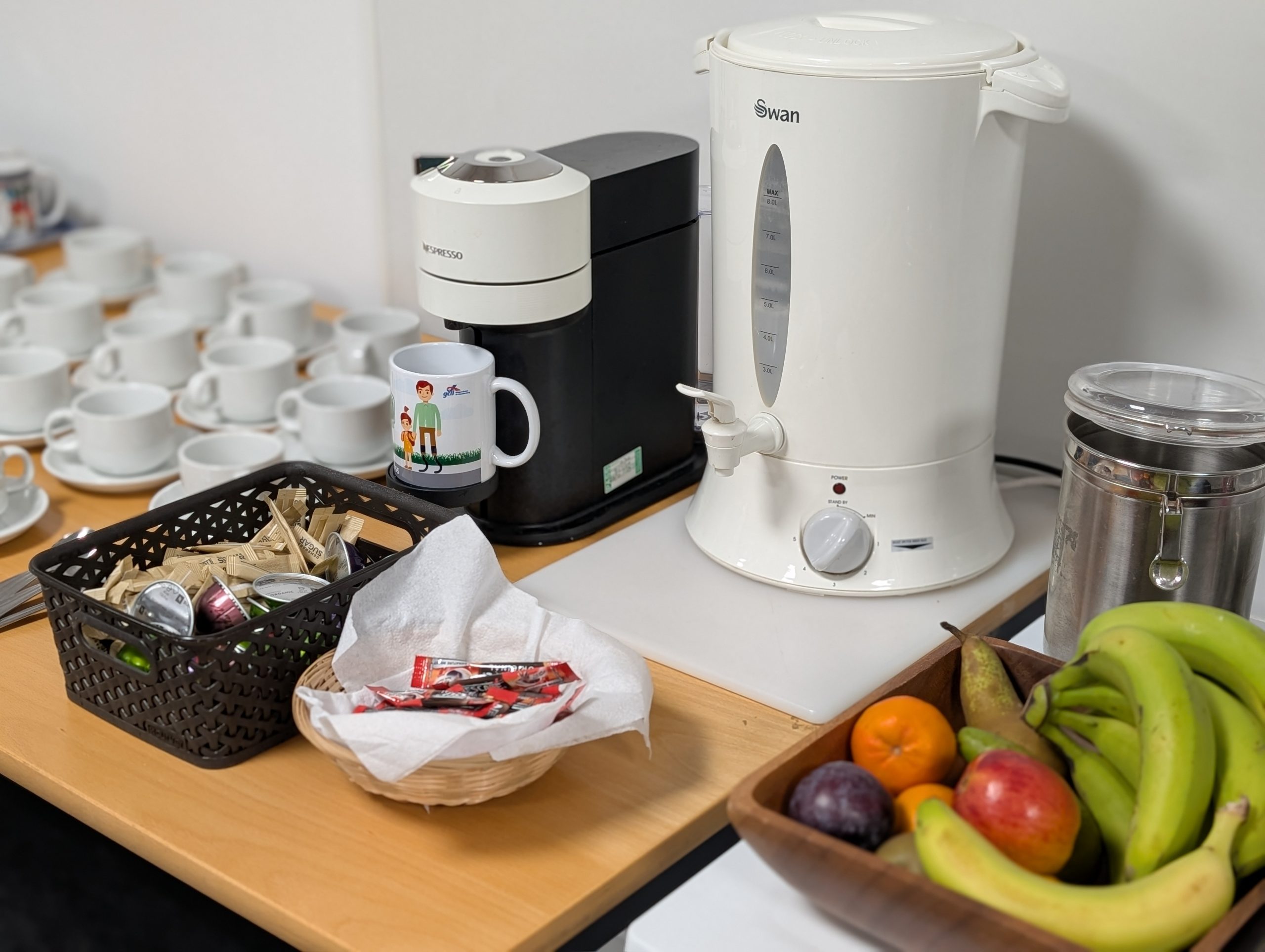 Table with coffee and tea making facilities and a bowl of fruit