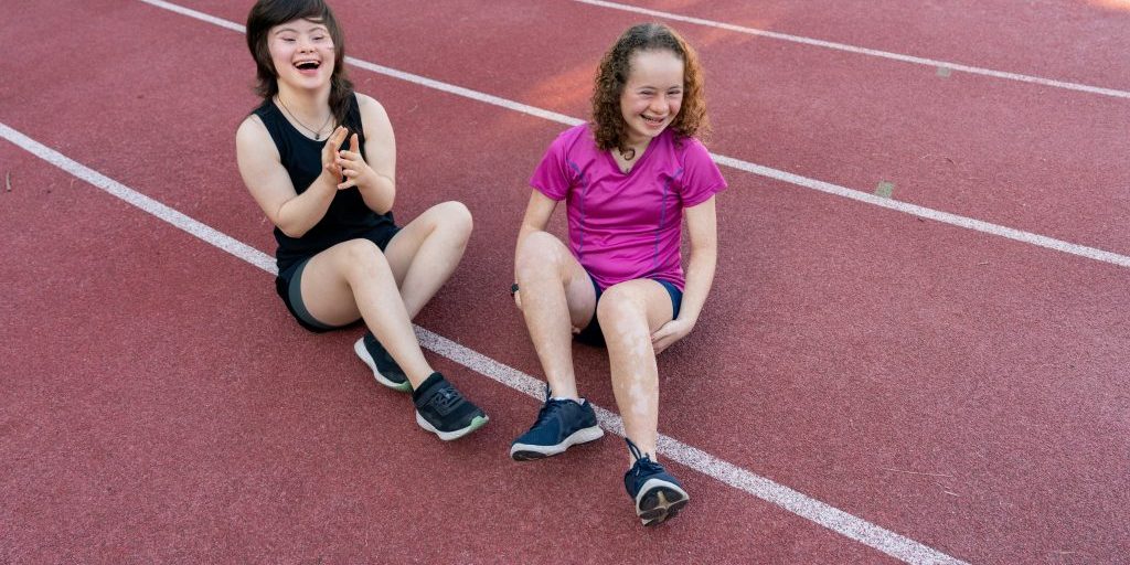 Two people sitting down on a running track